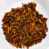 Premium loose herbal smoking blend containing shredded aromatic botanicals inside a clear container